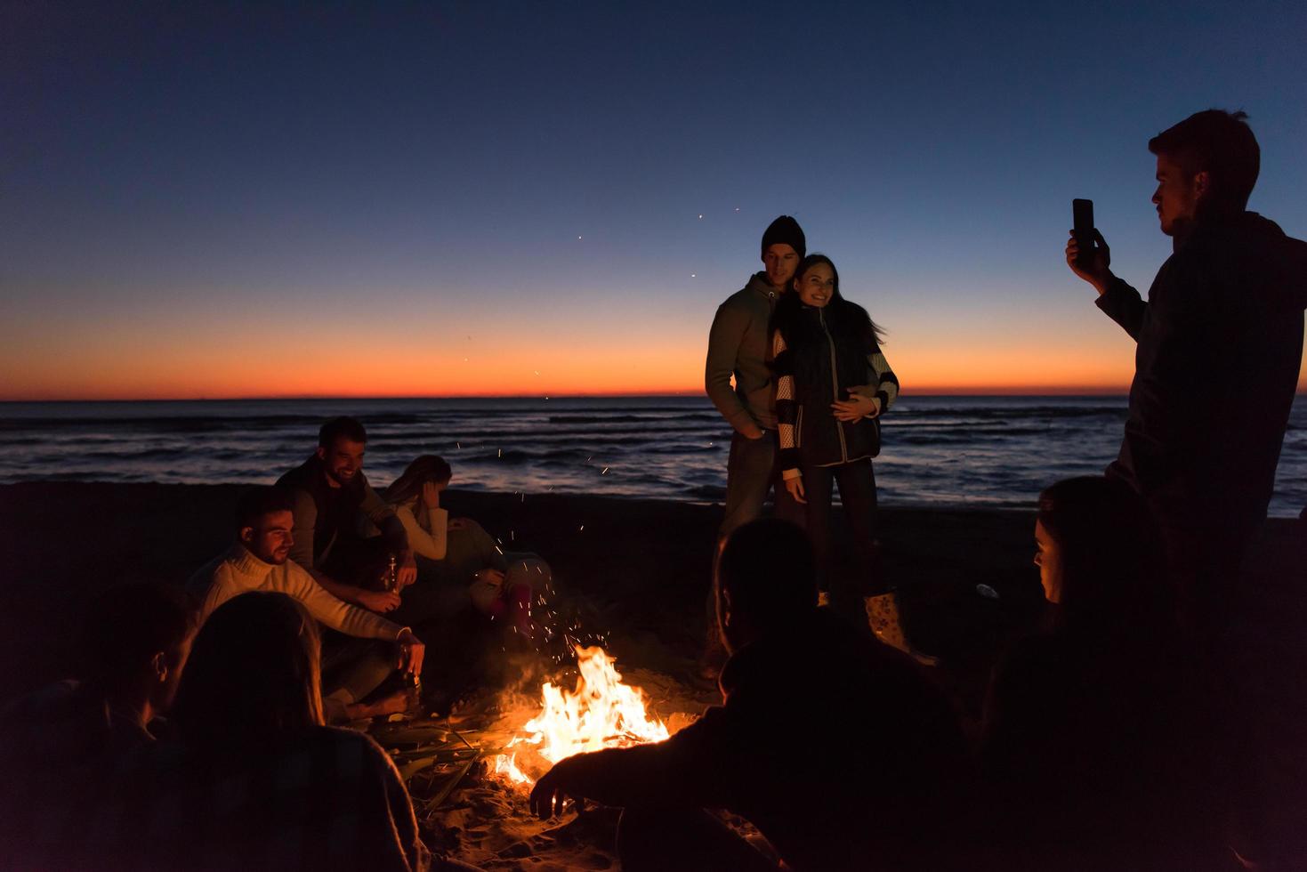 Friends having fun at beach on autumn day photo