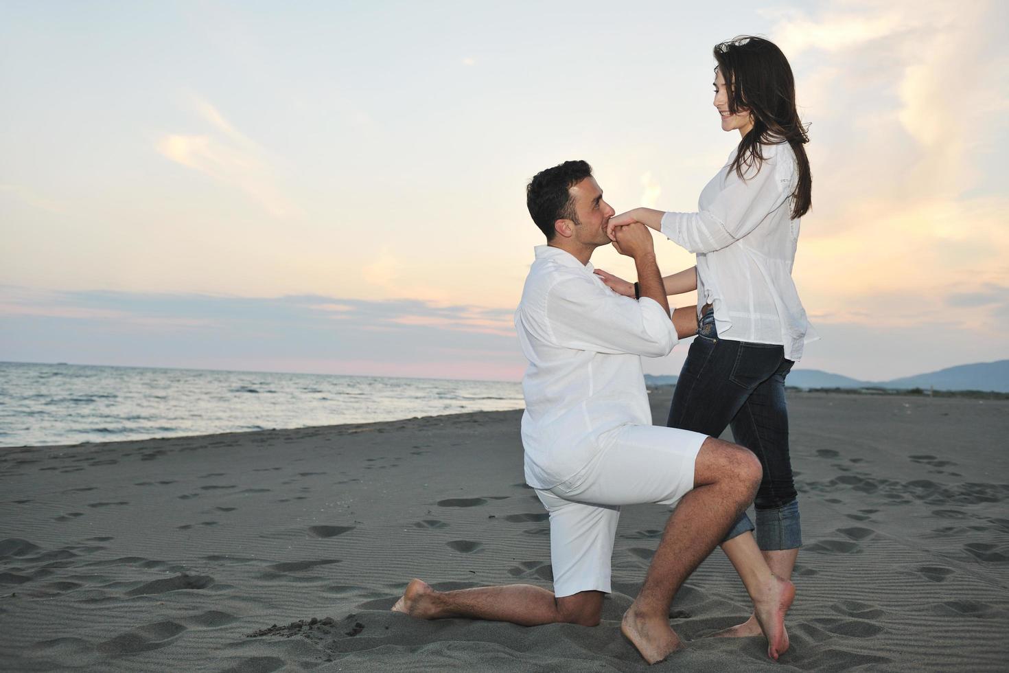 feliz pareja joven divertirse en la playa foto