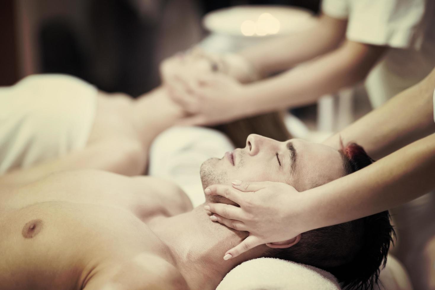 pareja joven relajada recibiendo masajes en el spa foto