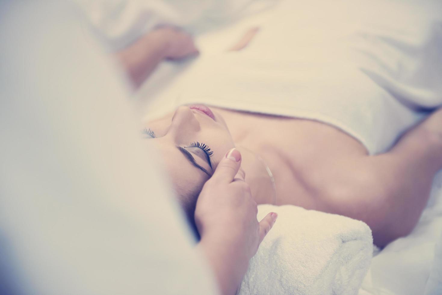 woman getting face and head  massage in spa salon photo