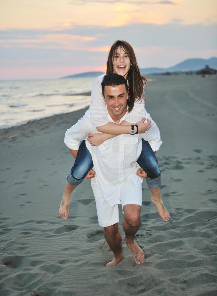 feliz pareja joven divertirse en la playa foto