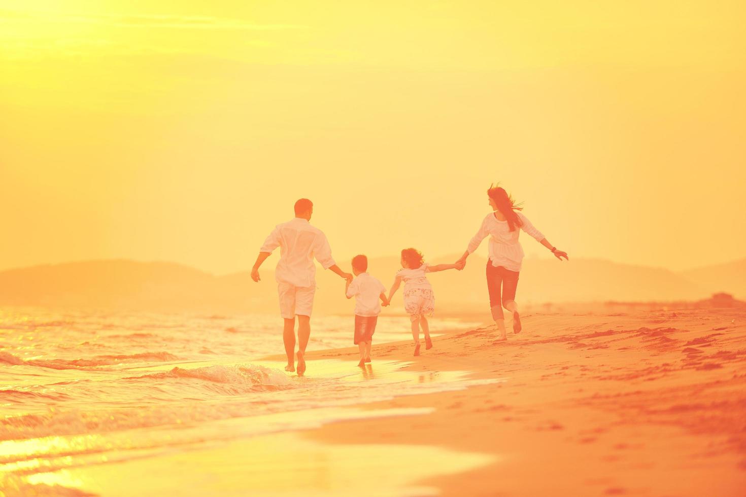 happy young family have fun on beach at sunset photo