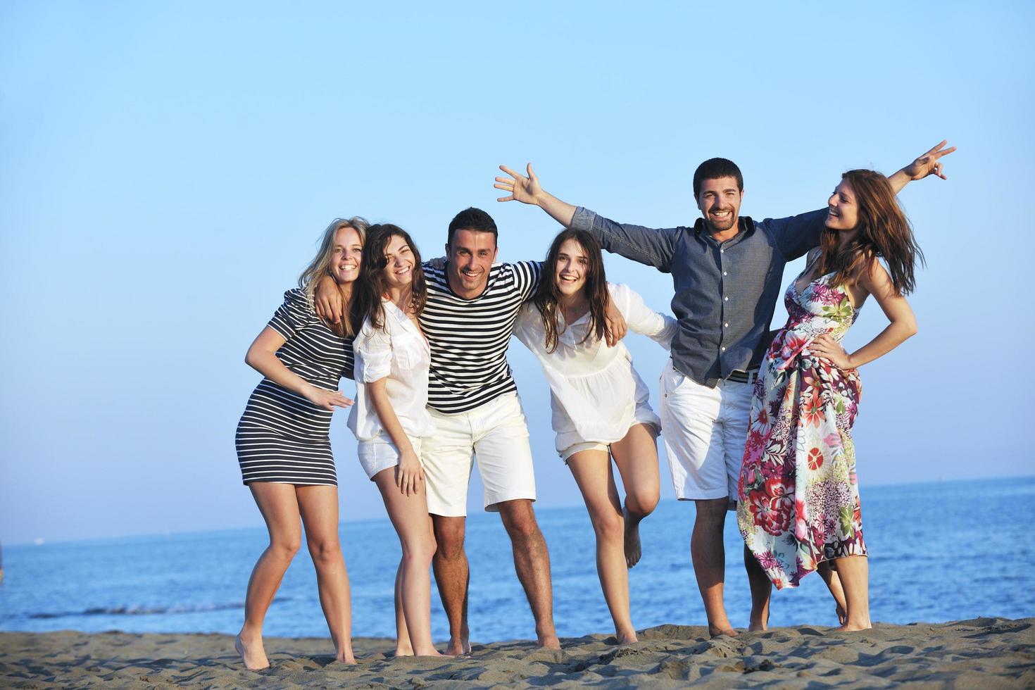 happy young  people group have fun on beach photo