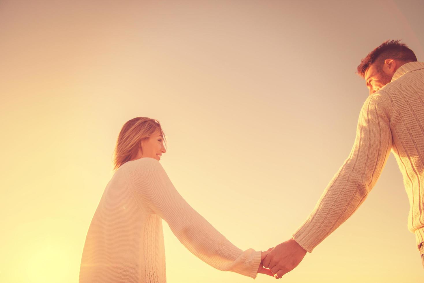 Loving young couple on a beach at autumn sunny day photo