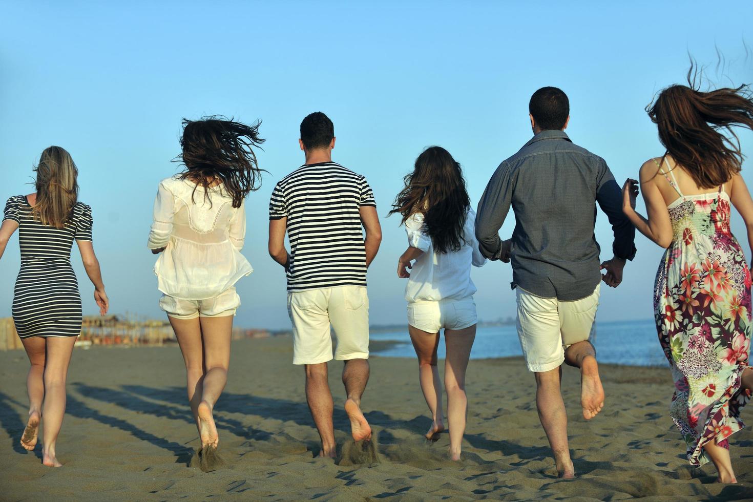 happy young  people group have fun on beach photo