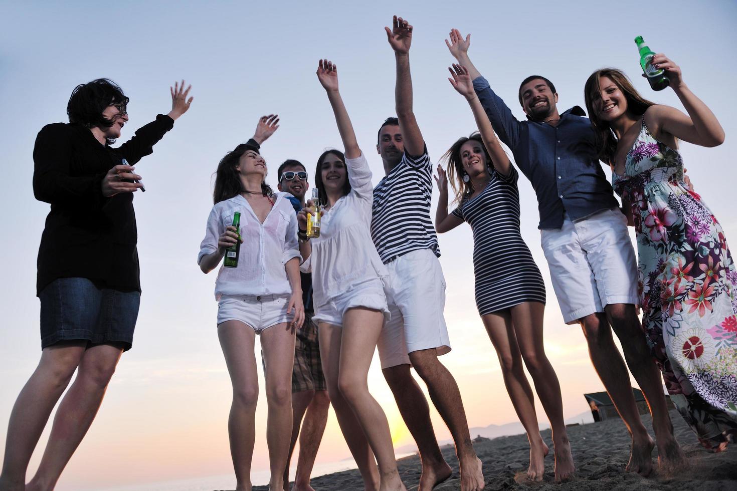 Group of young people enjoy summer  party at the beach photo