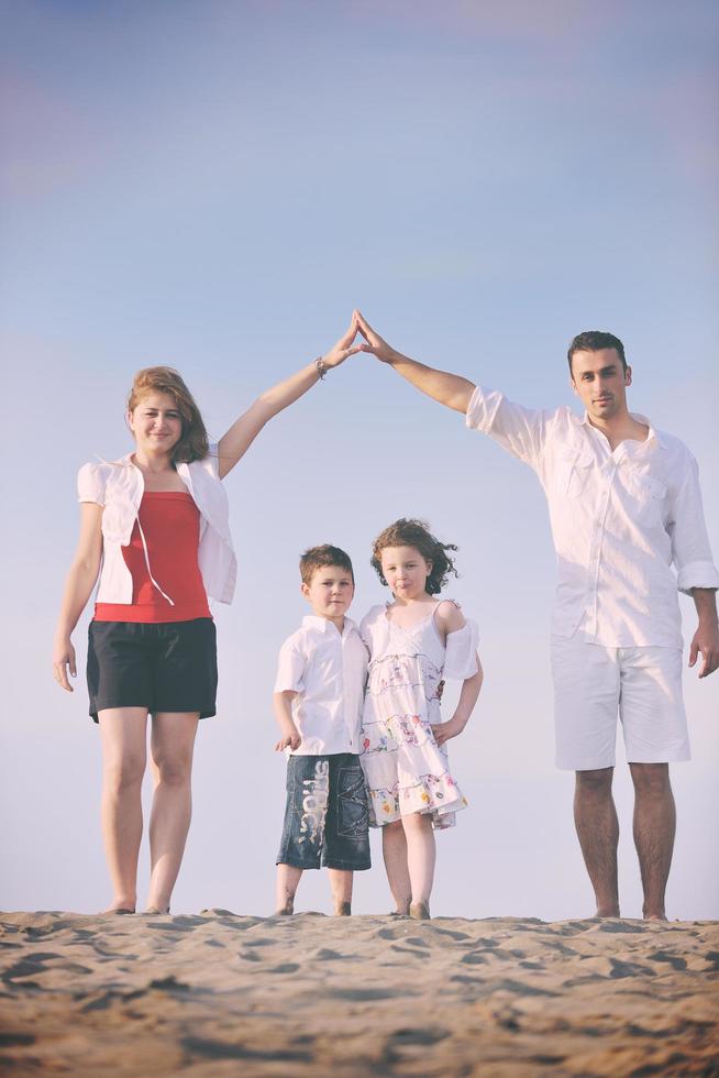 family on beach showing home sign photo