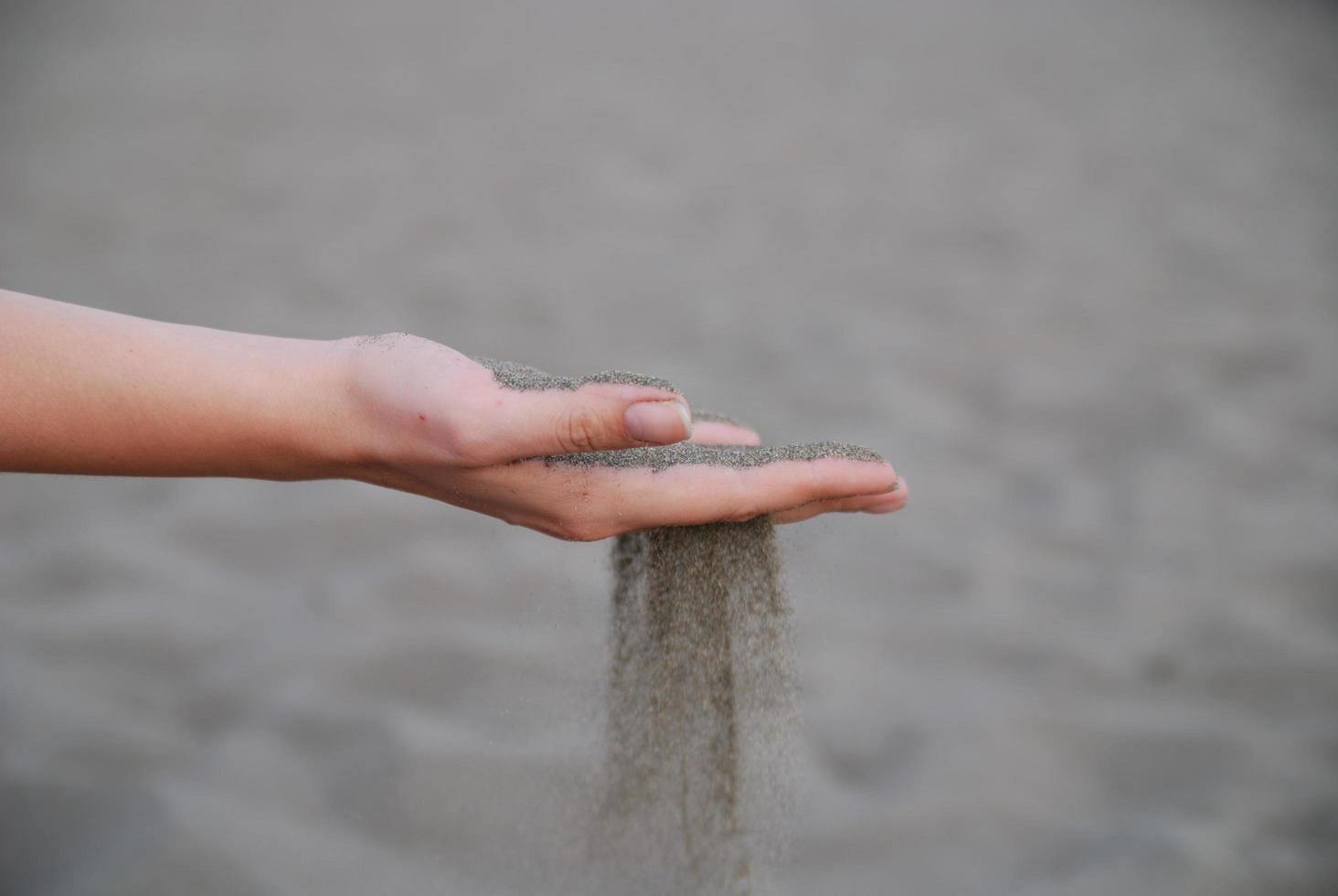 fine sand leaking trought woman hands photo