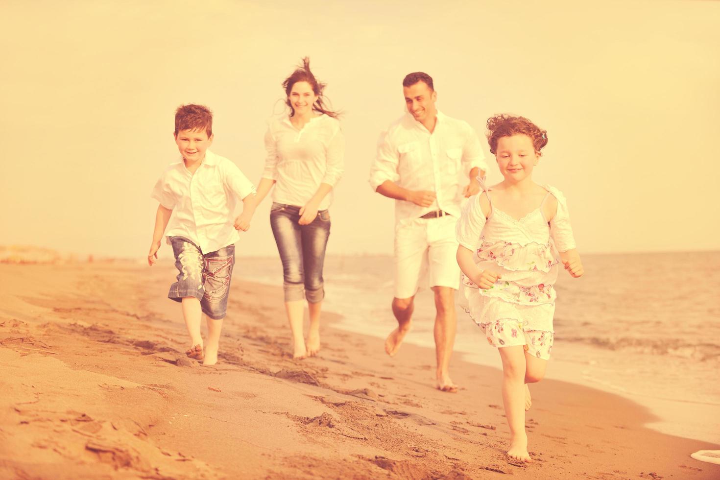 familia joven feliz divertirse en la playa foto