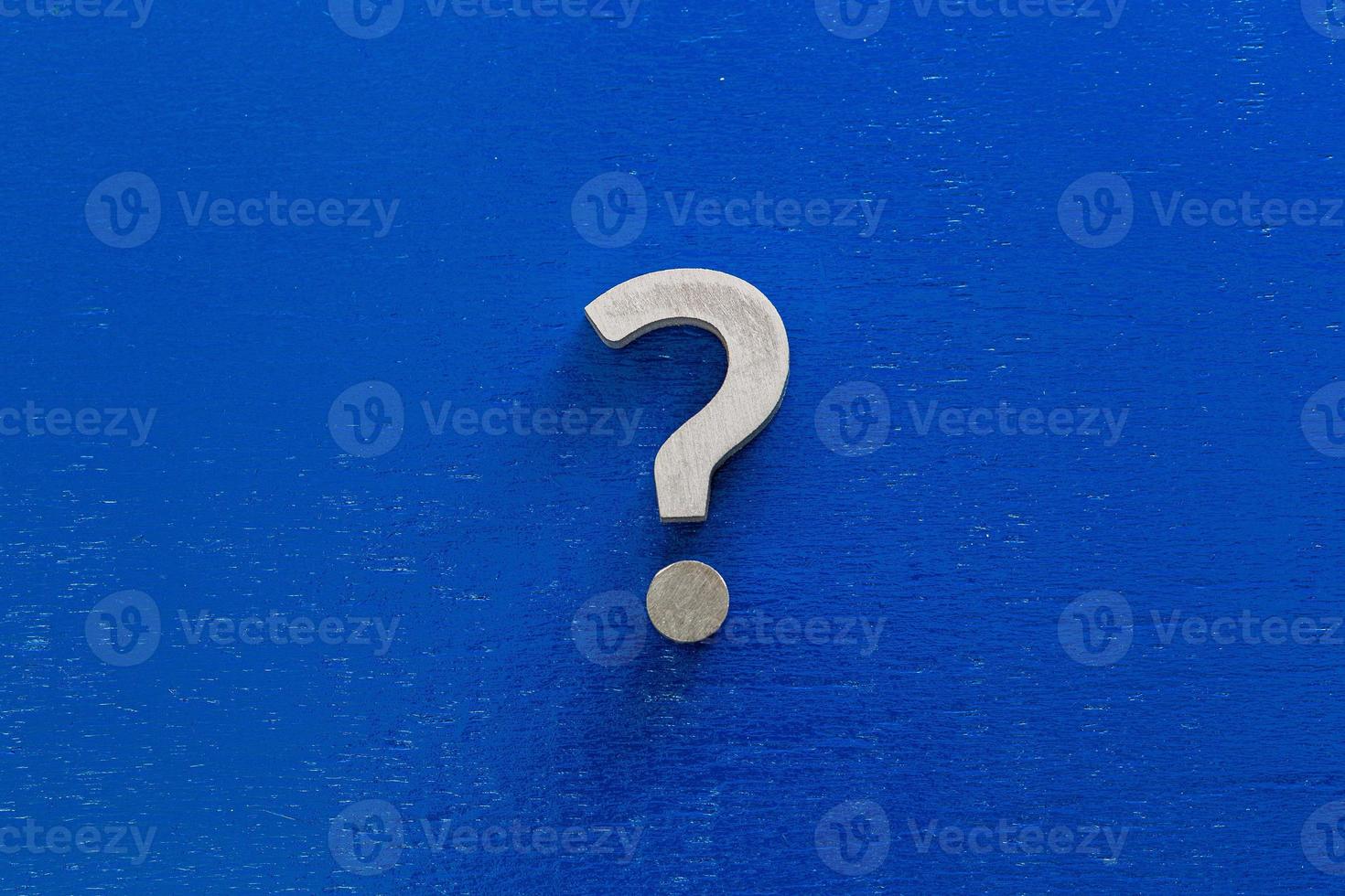 A question sign on center of blue painted board - flat lay conept photo