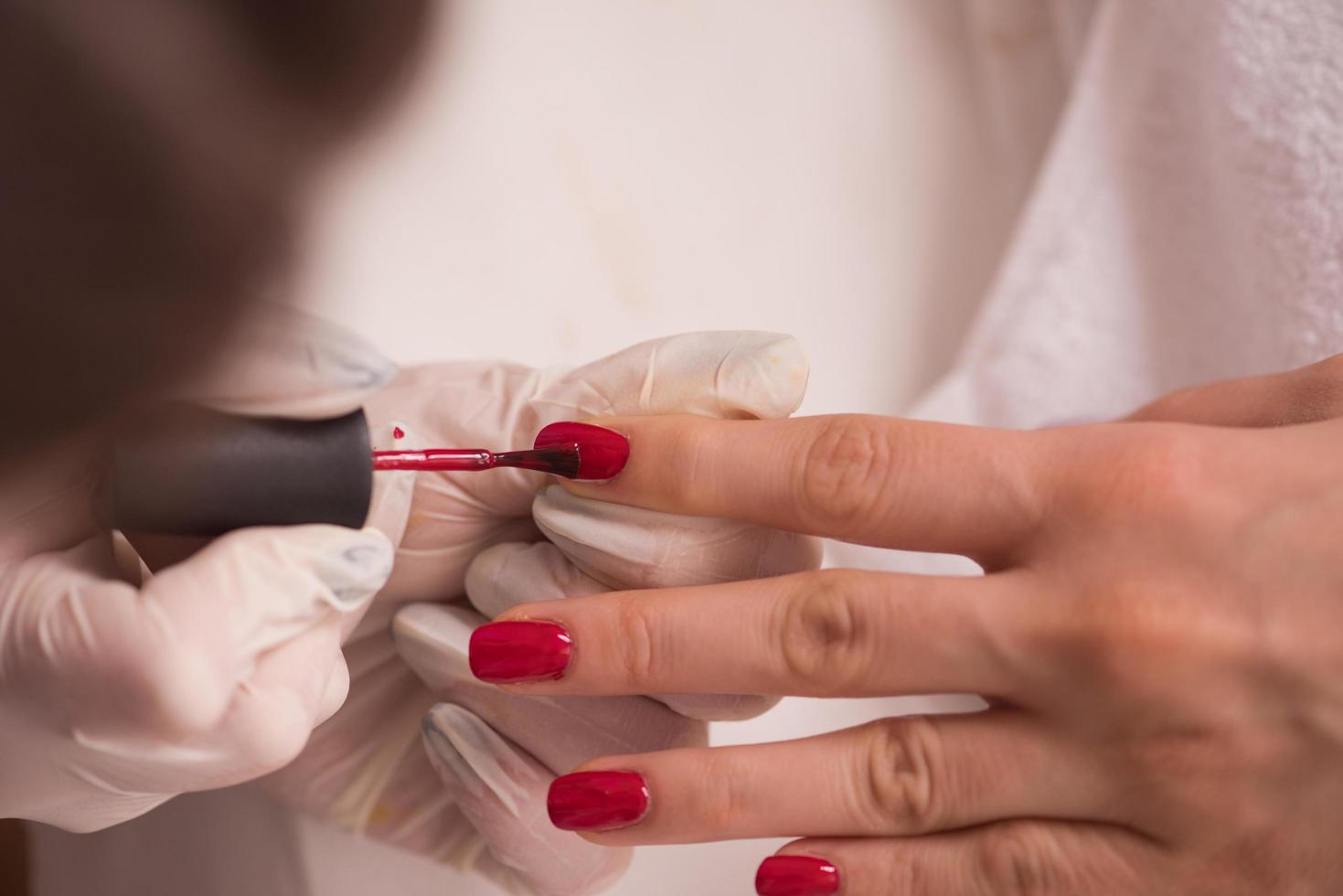 manos de mujer recibiendo una manicura foto