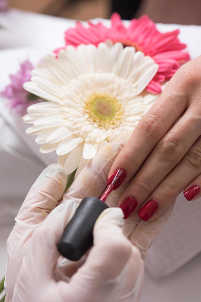 manos de mujer recibiendo una manicura foto