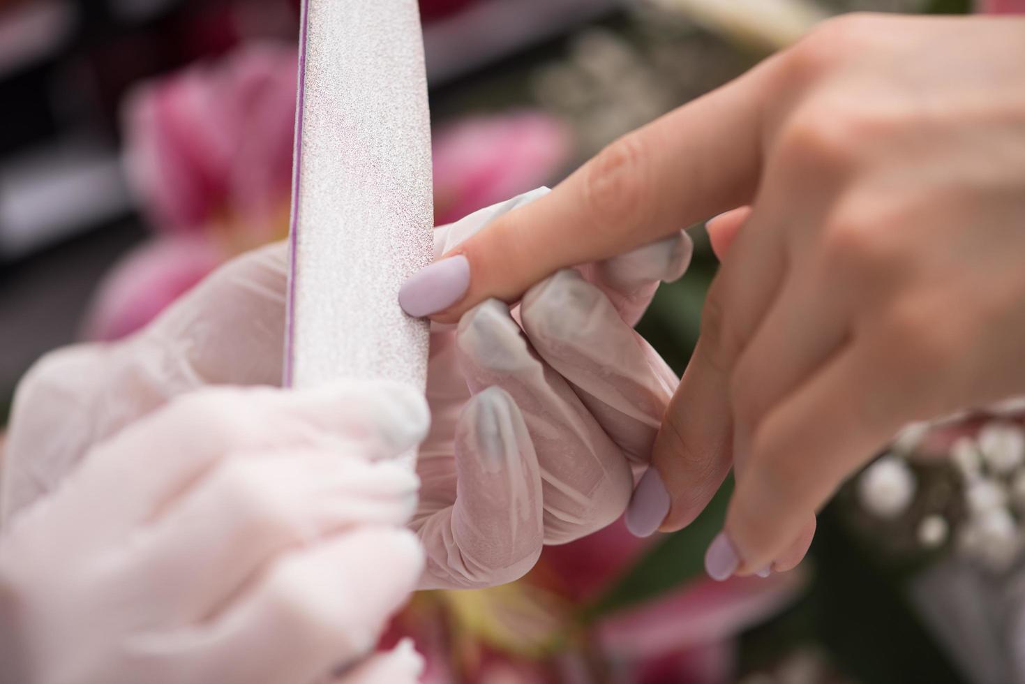 manos de mujer recibiendo una manicura foto