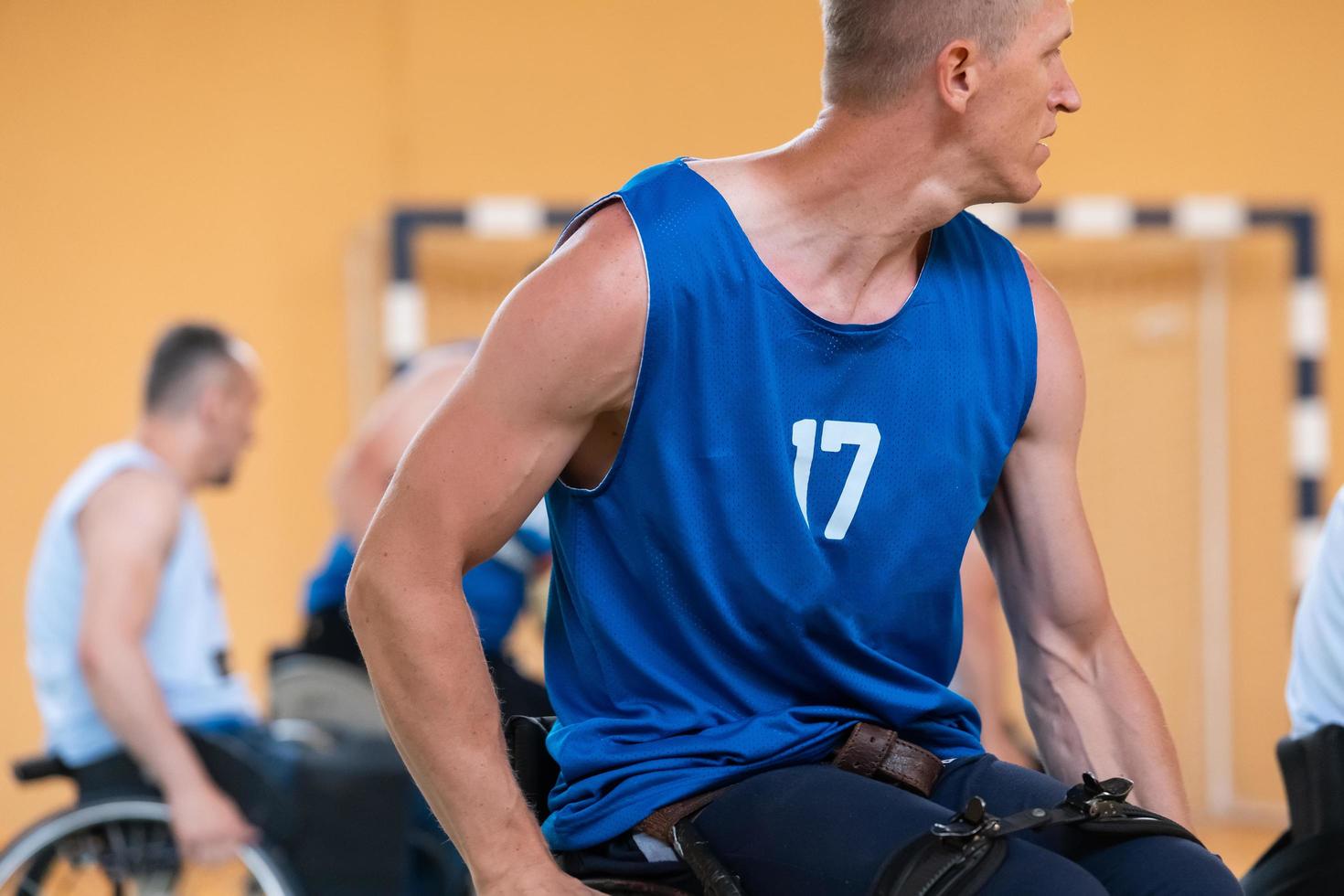 veteranos de guerra discapacitados en acción mientras juegan baloncesto en una cancha de baloncesto con equipo deportivo profesional para discapacitados foto