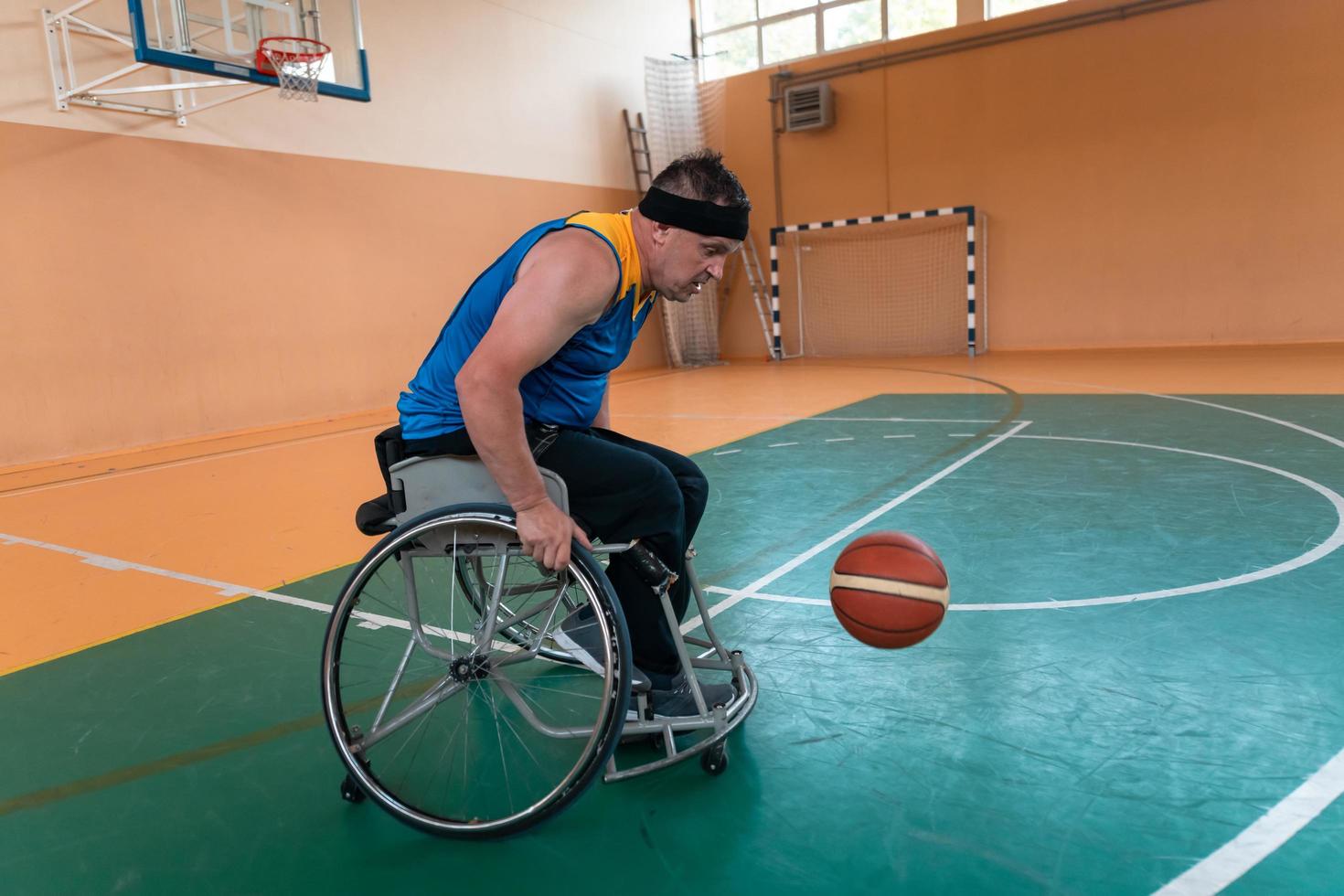 Disabled War veterans mixed race and age basketball teams in wheelchairs playing a training match in a sports gym hall. Handicapped people rehabilitation and inclusion concept photo