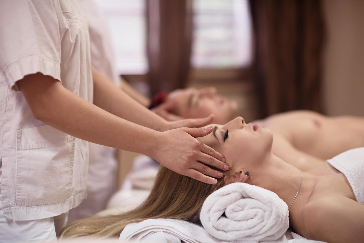 couple enjoying head massage at the spa photo