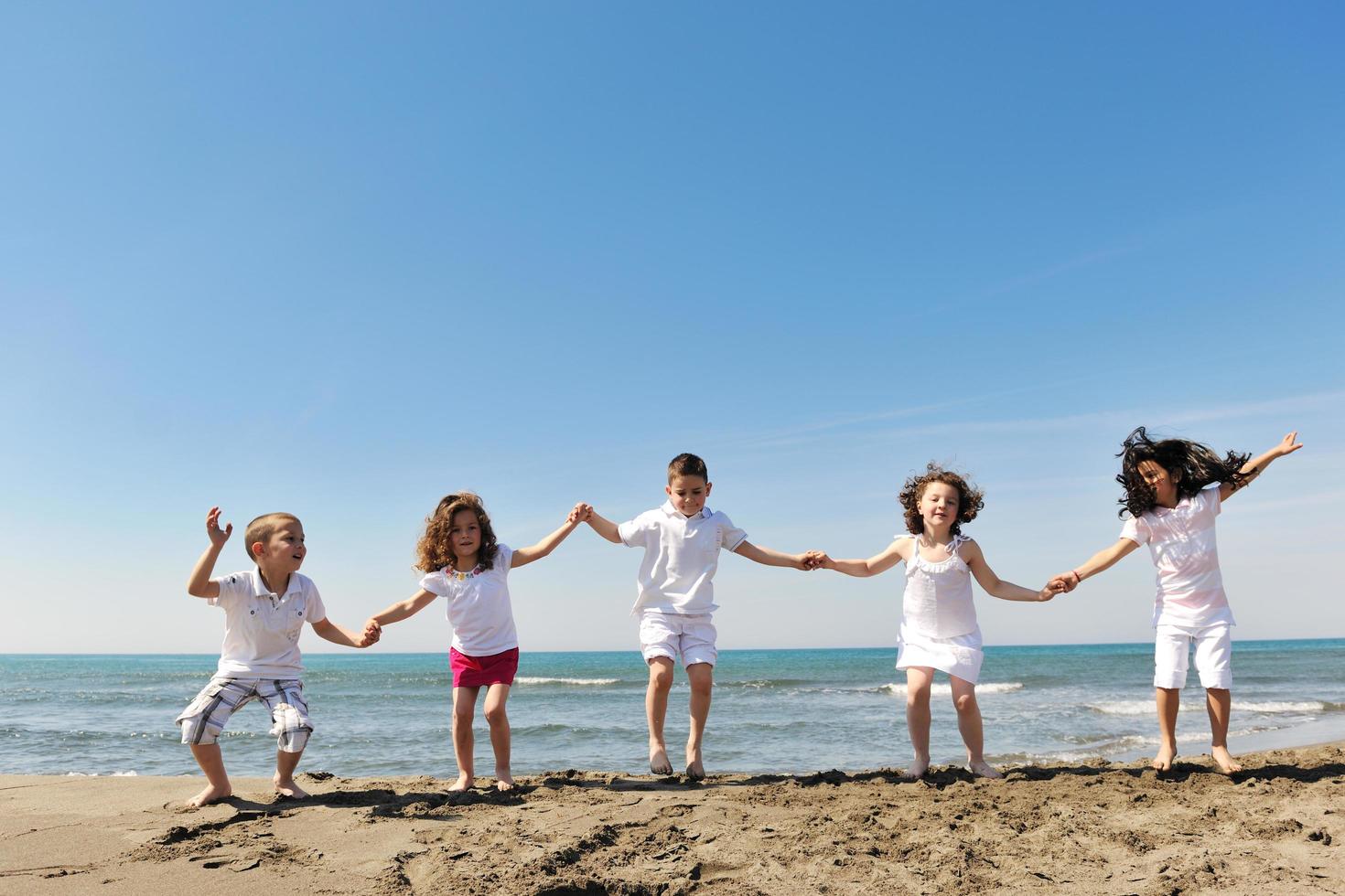 happy child group playing  on beach photo