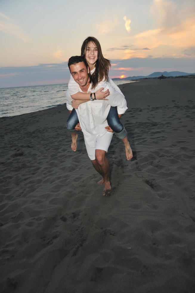 feliz pareja joven divertirse en la playa foto