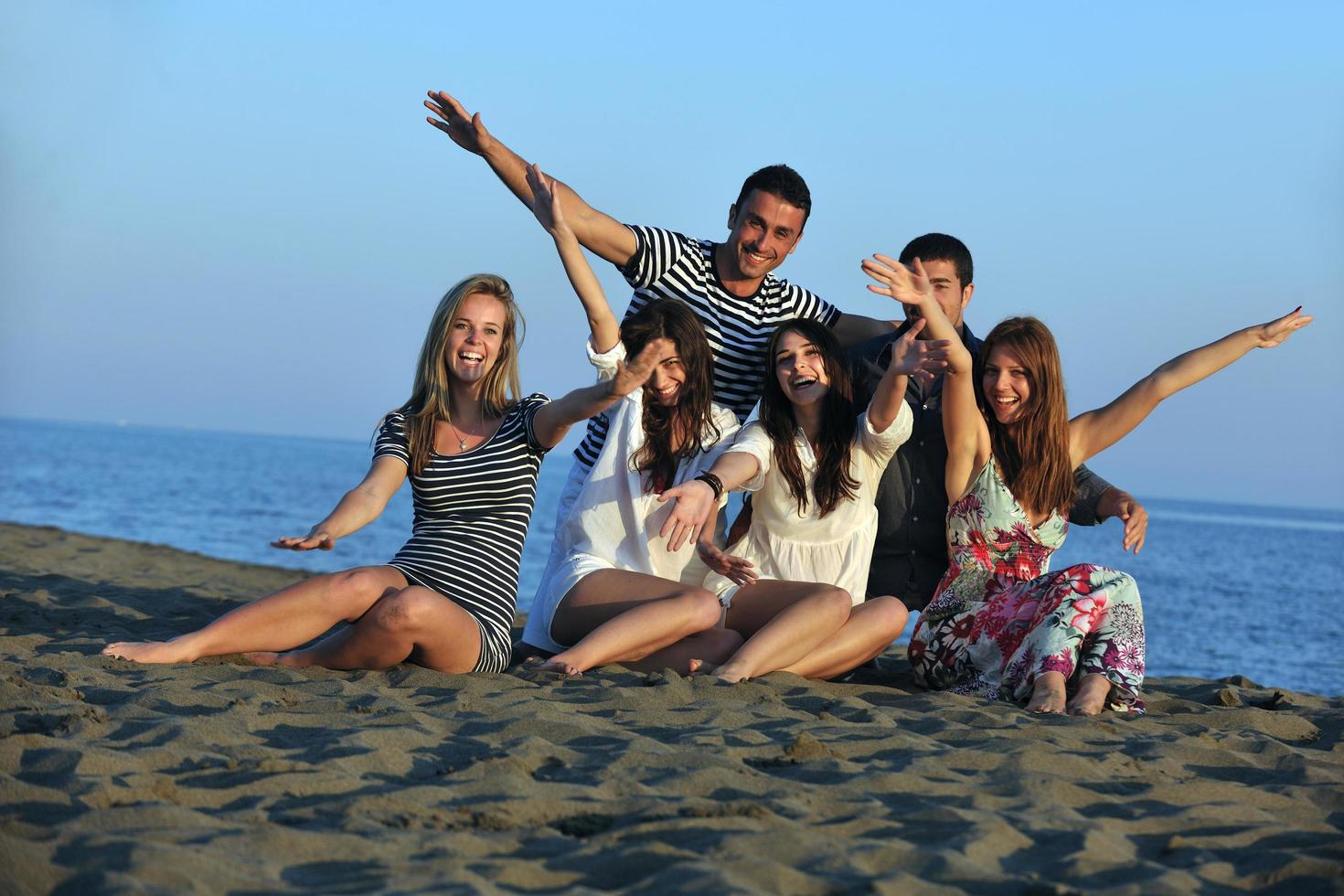 happy young  people group have fun on beach photo