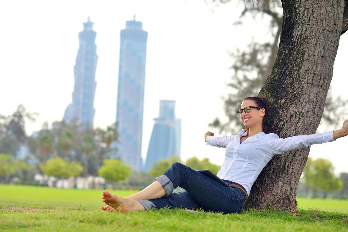 Beautiful young woman with  tablet in park photo