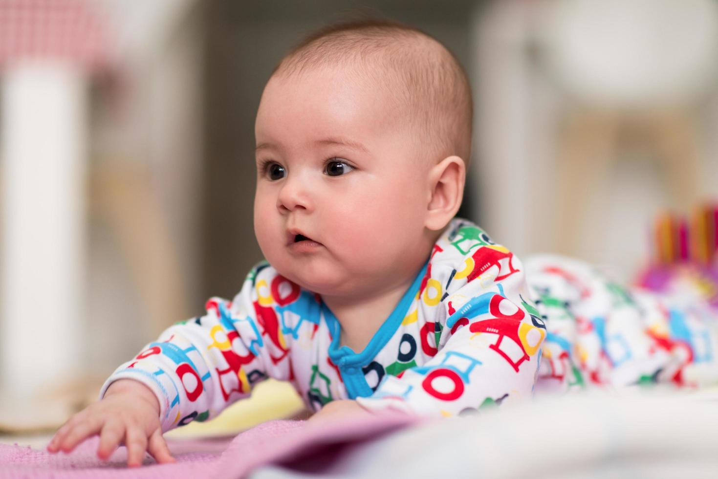 newborn baby boy playing on the floor photo