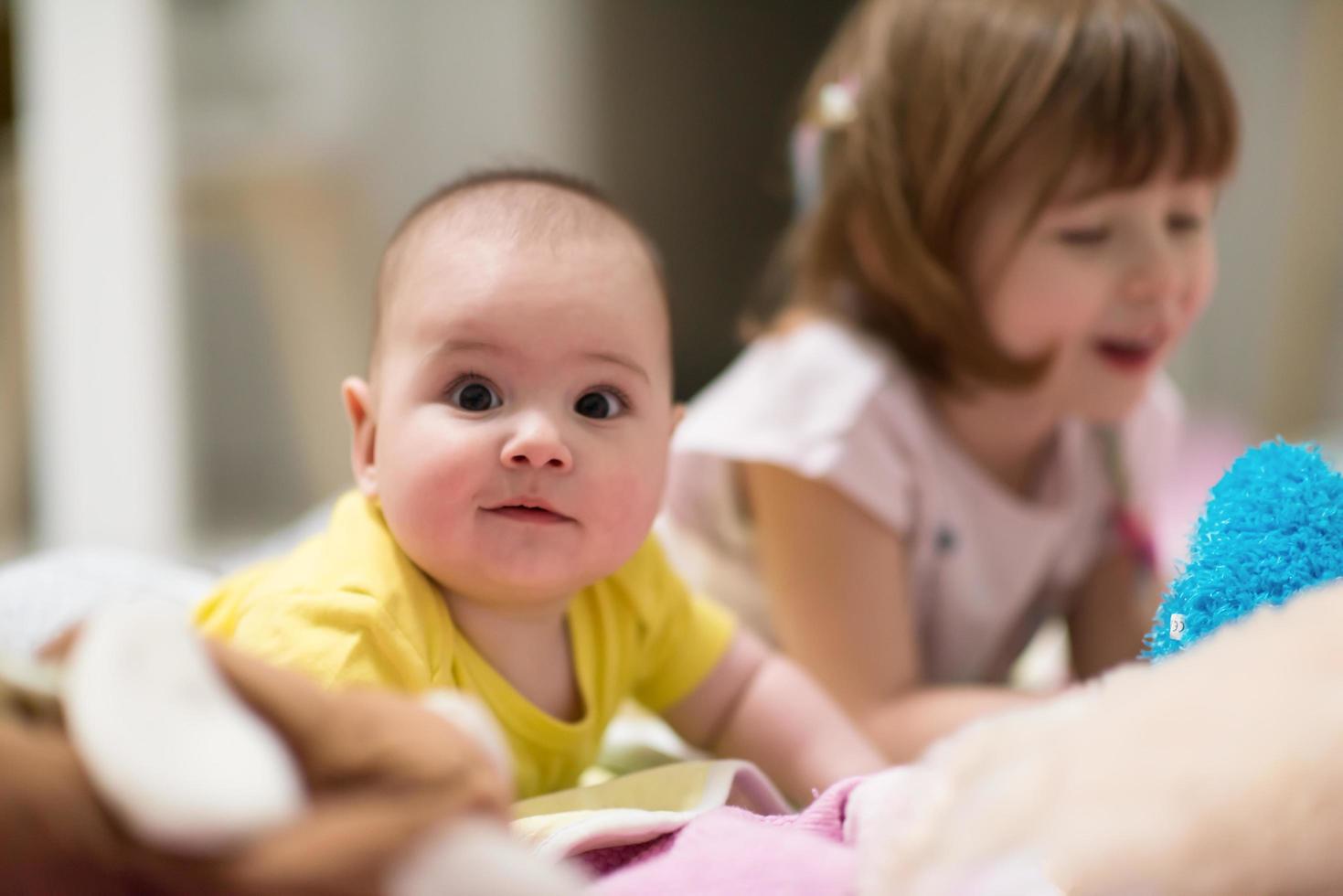 little sister and her baby brother playing at home photo