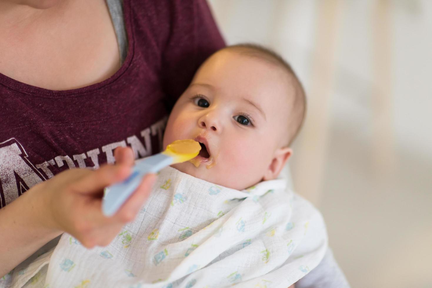 mother with spoon feeding little baby photo