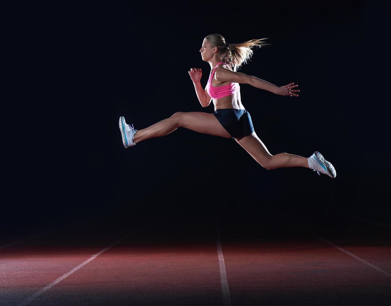 Athletic woman running on track photo