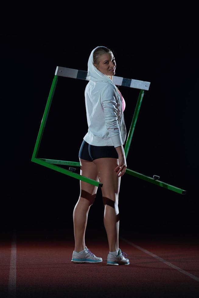 woman athlete jumping over a hurdles photo