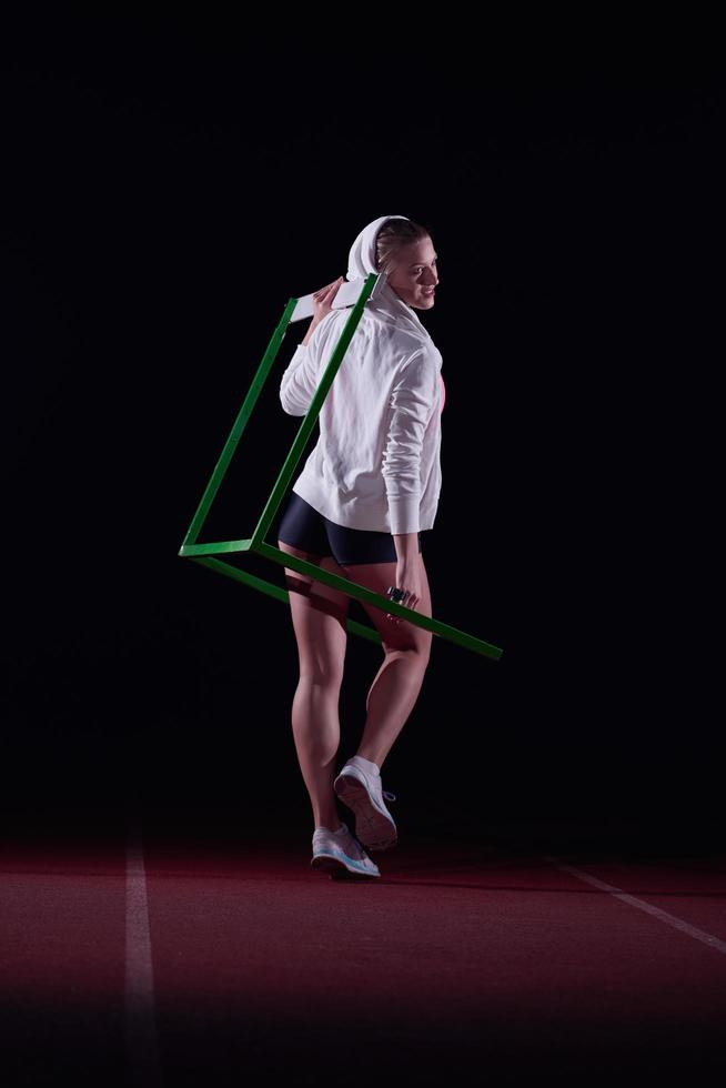 woman athlete jumping over a hurdles photo