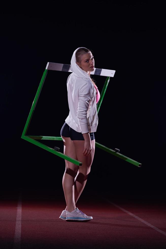 woman athlete jumping over a hurdles photo