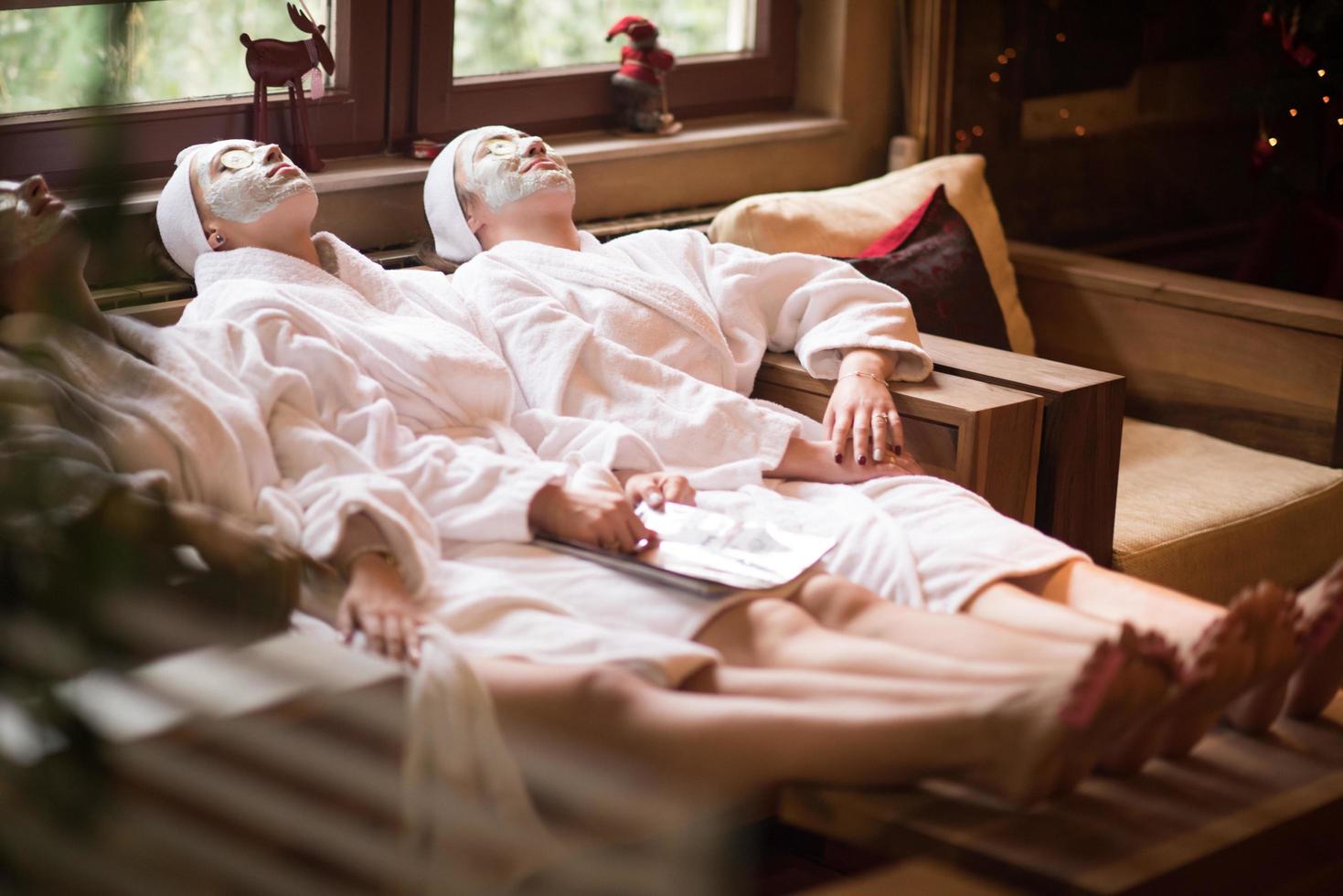 las mujeres reciben mascarilla facial de arcilla en el spa foto