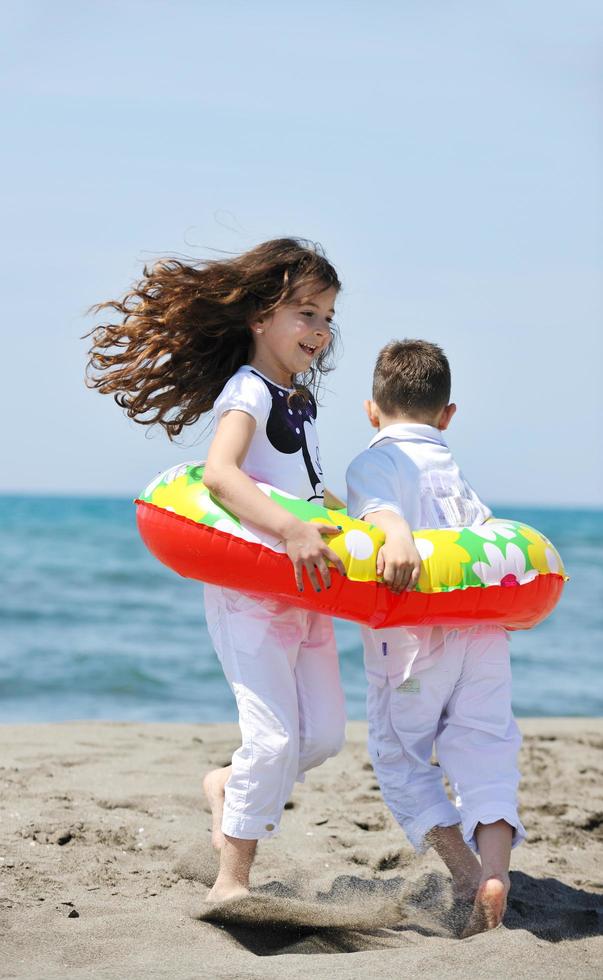 Grupo de niños felices jugando en la playa foto