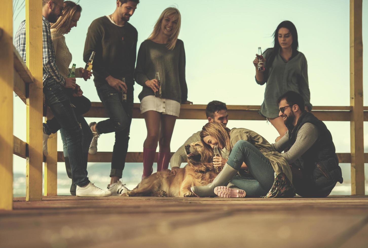 grupo de amigos divirtiéndose el día de otoño en la playa foto