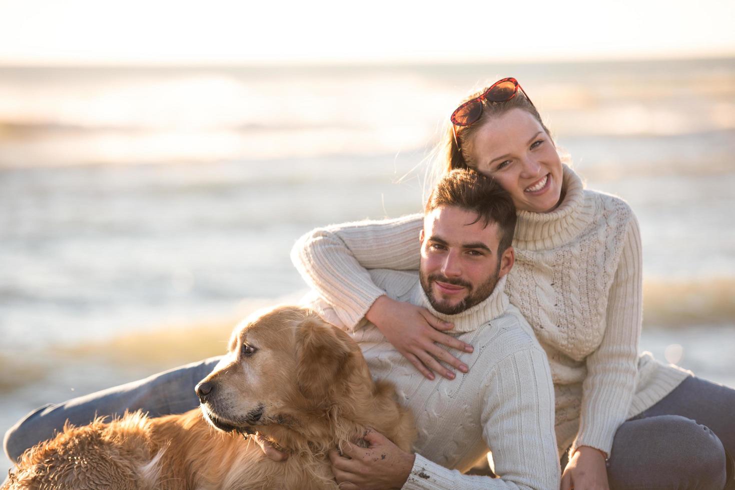 Couple with dog enjoying time on beach photo
