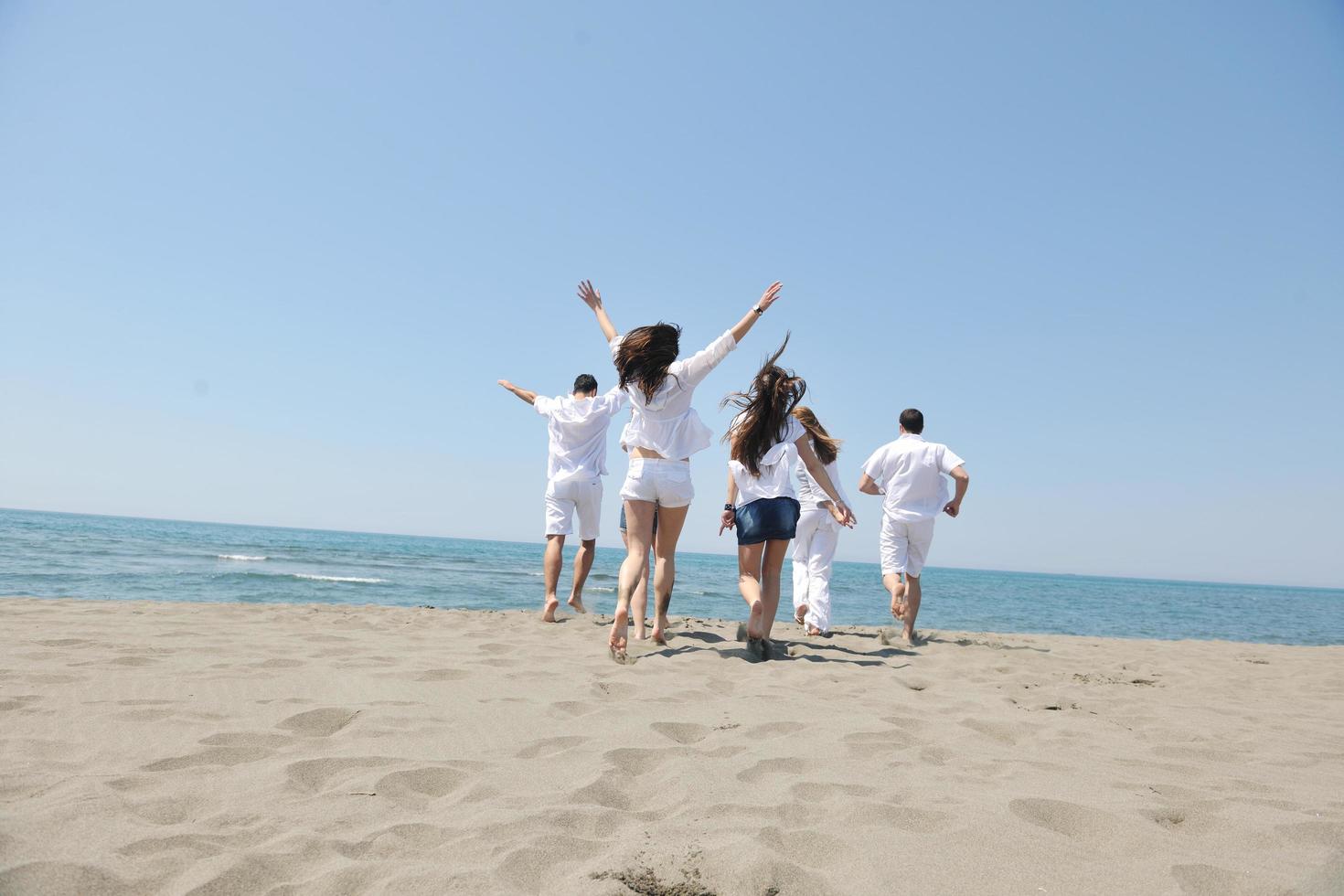 happy people group have fun and running on beach photo