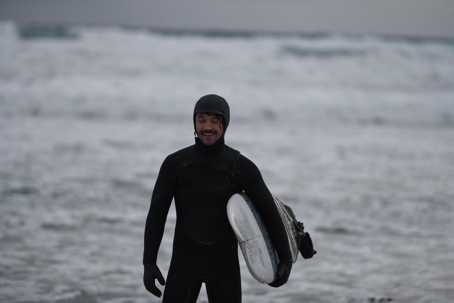 Arctic surfer going by beach after surfing photo