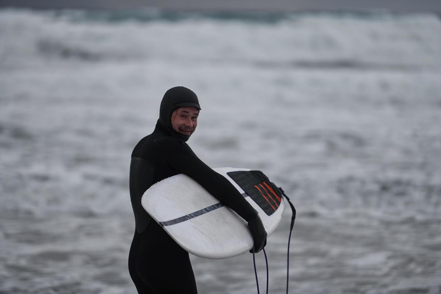 Arctic surfer going by beach after surfing photo