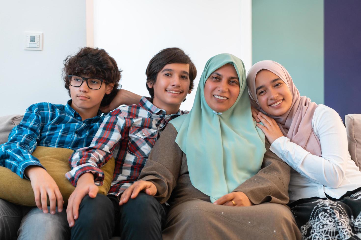 Middle eastern family portrait single mother with teenage kids at home in living room. Selective focus photo