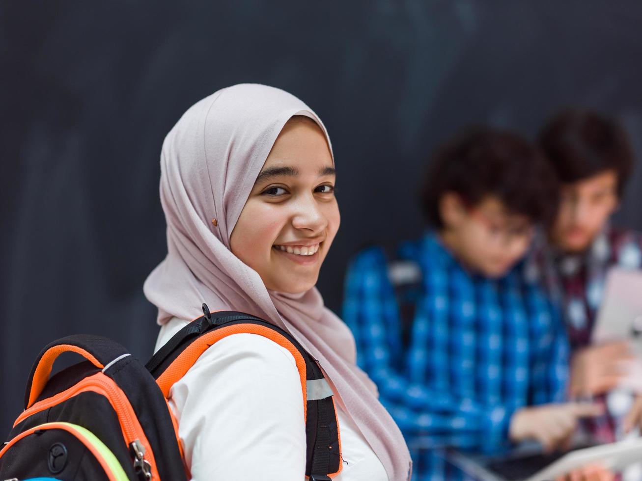 Modern arab teens use smartphone, tablet and latpop to study during online classes due to corona virus pandemic photo