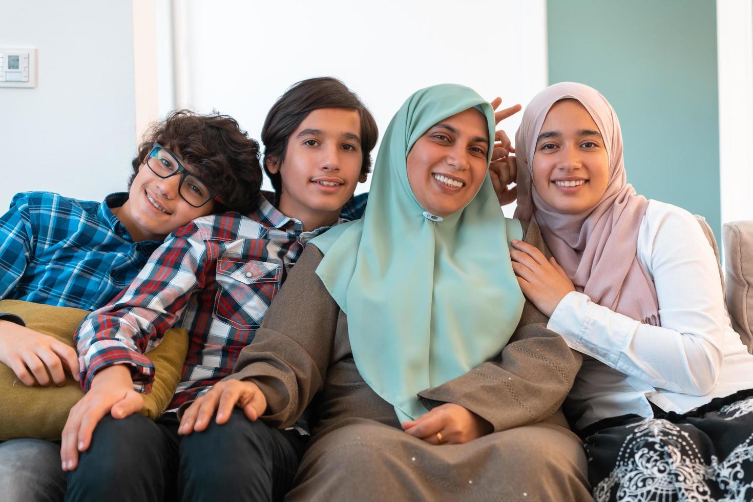 Middle eastern family portrait single mother with teenage kids at home in living room. Selective focus photo