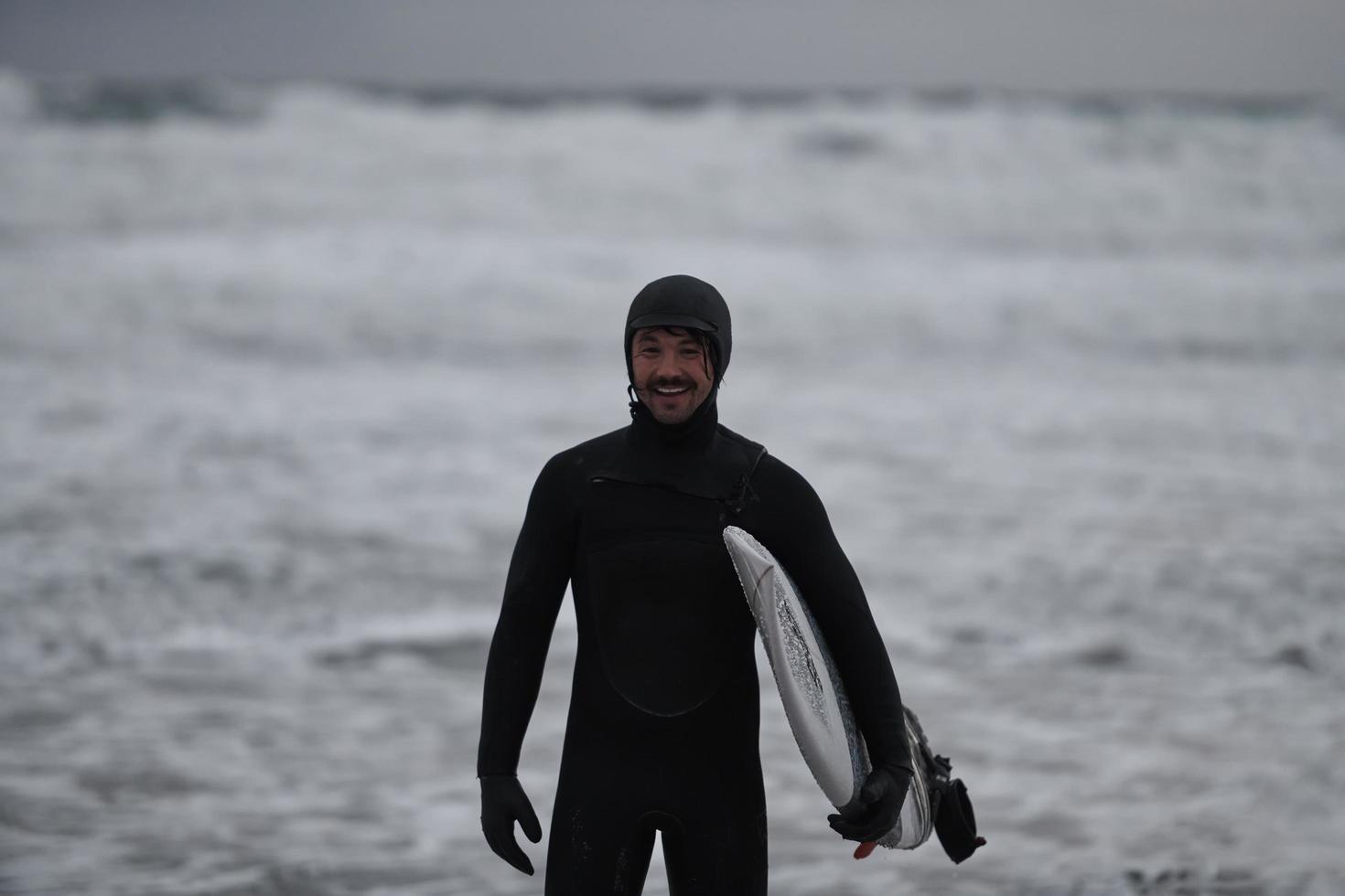 Arctic surfer going by beach after surfing photo