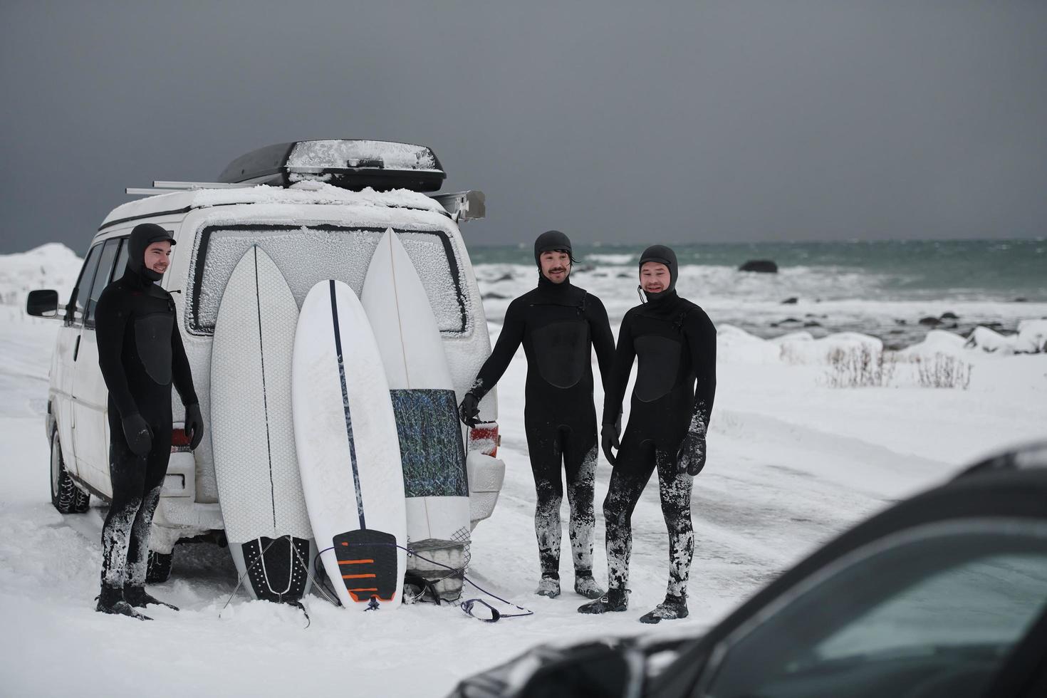 Arctic surfers in wetsuit after surfing by minivan photo