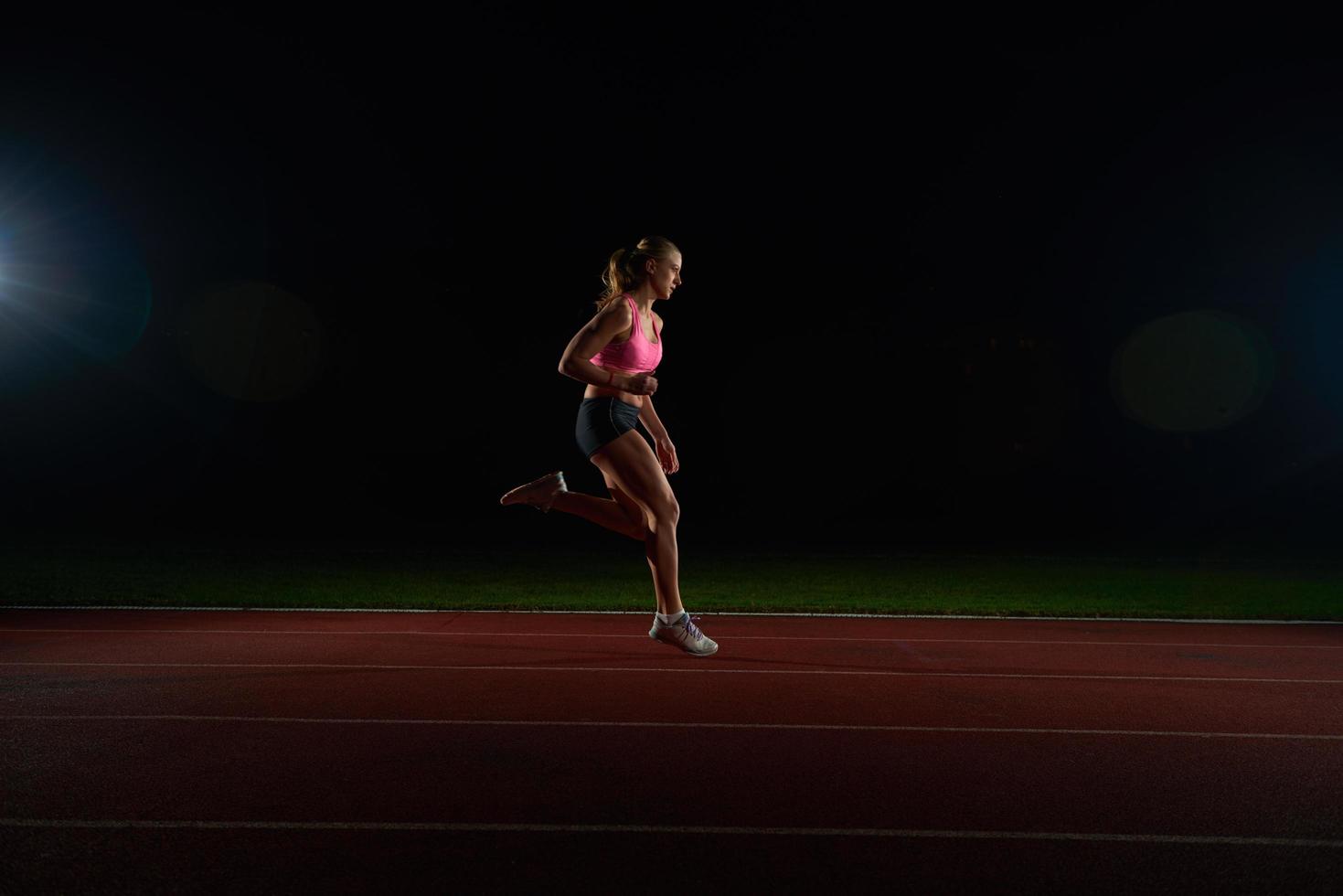 Athletic woman running on track photo