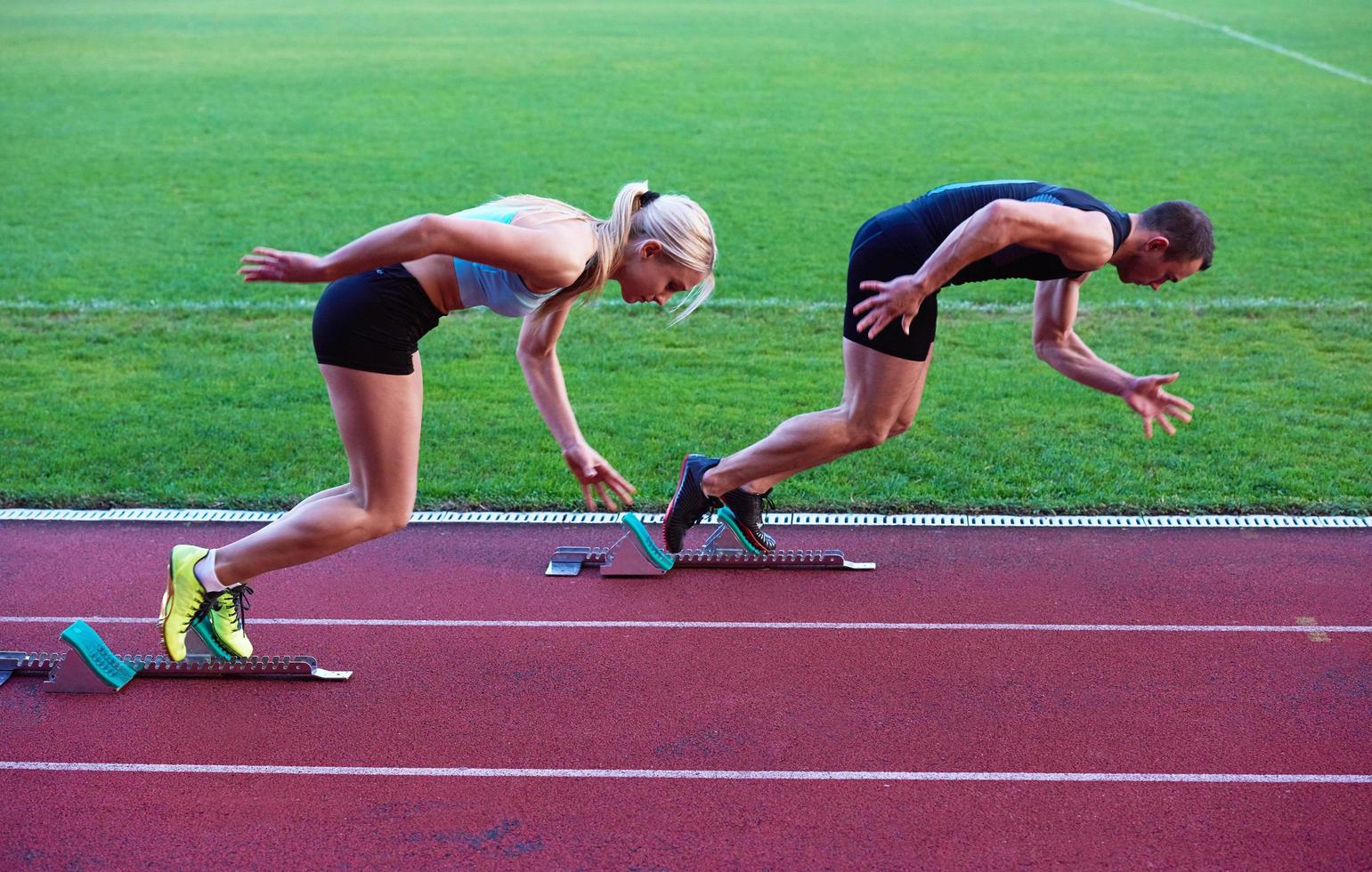 woman group  running on athletics race track from start photo