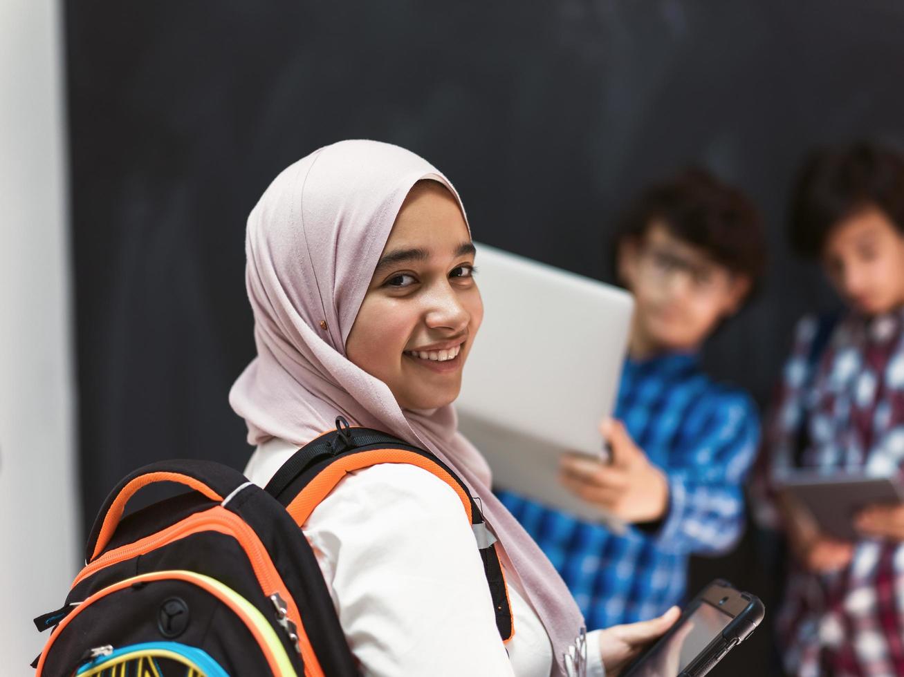 Modern arab teens use smartphone, tablet and latpop to study during online classes due to corona virus pandemic photo