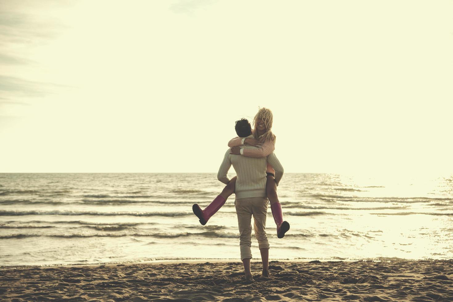 amorosa pareja joven en una playa en el día soleado de otoño foto