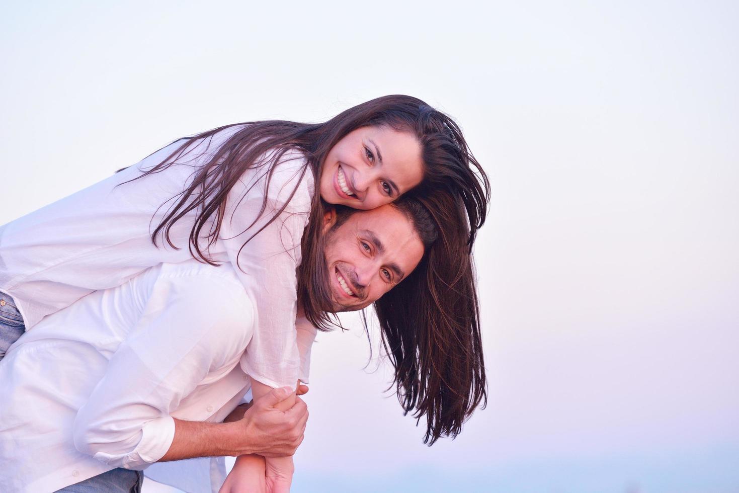 pareja joven en la playa divertirse foto