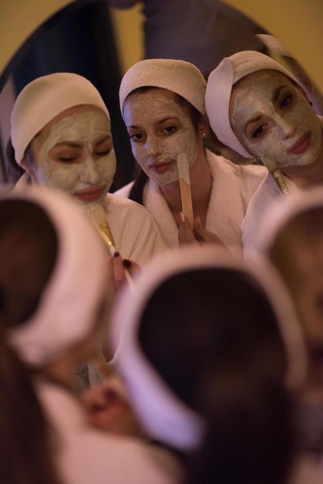 women putting face masks in the bathroom photo