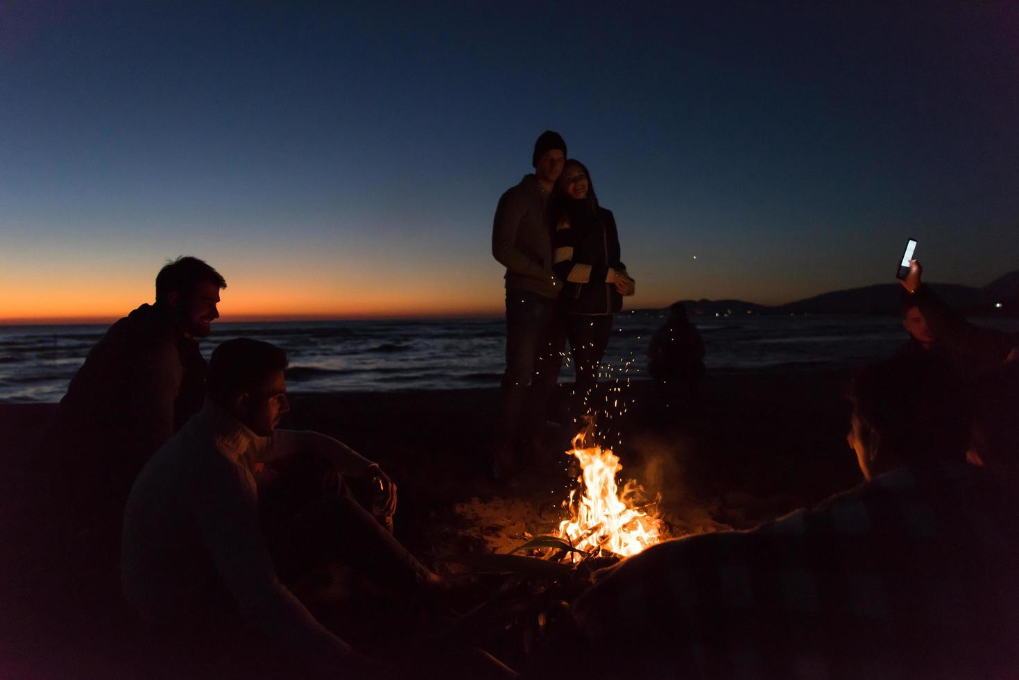 Friends having fun at beach on autumn day photo